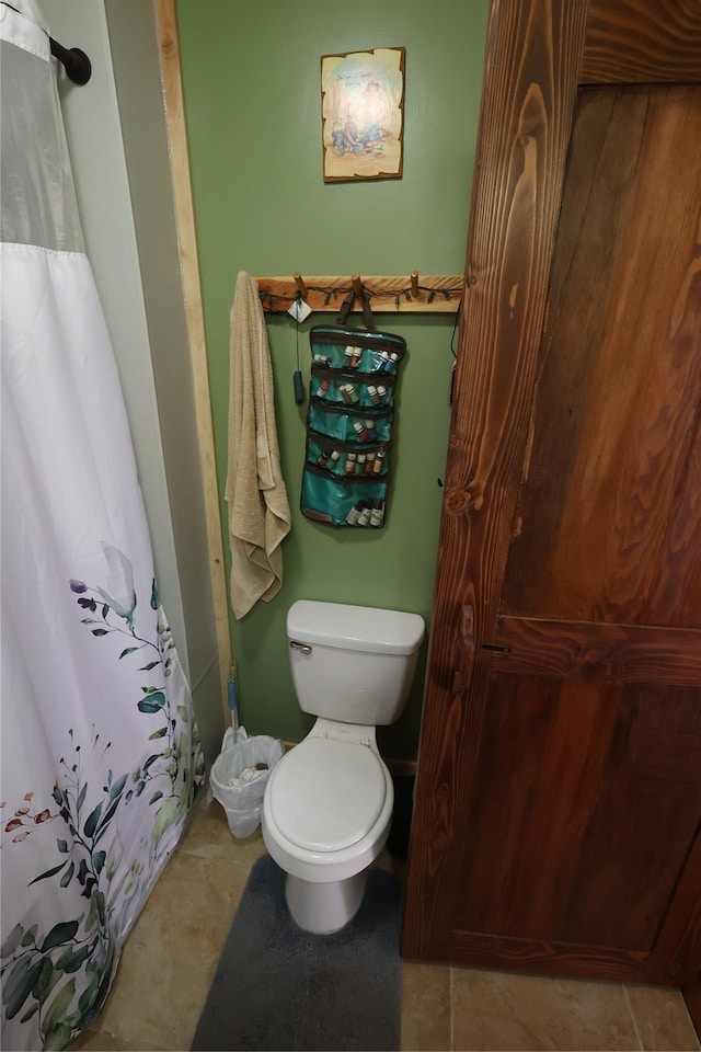 full bath featuring toilet and a shower with shower curtain