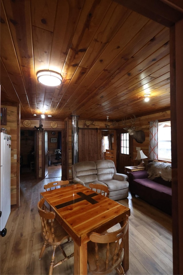 dining area featuring wooden walls, wood-type flooring, and wooden ceiling