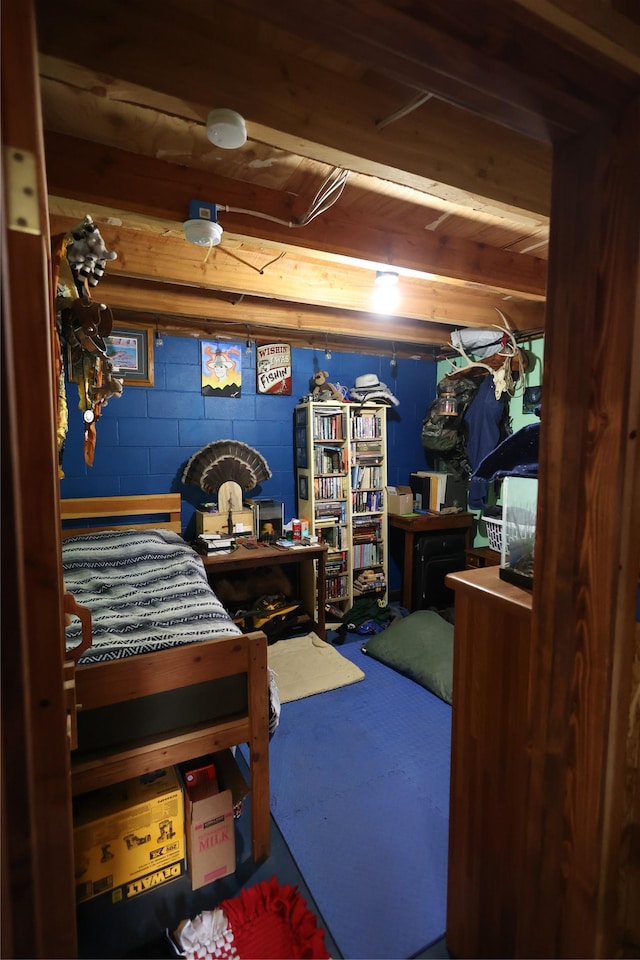 bedroom featuring concrete block wall