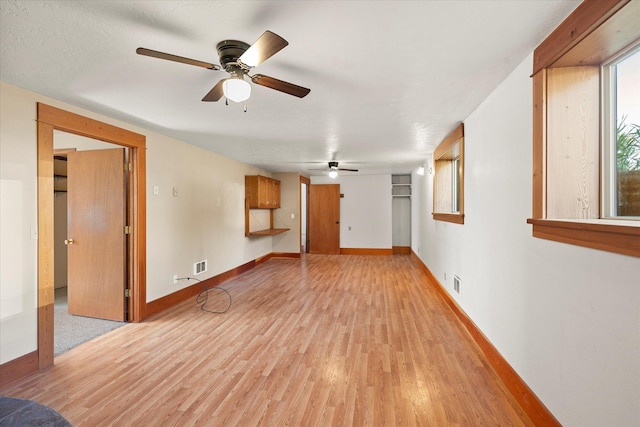 1108 9th St E, Polson, MT 59860 - unfurnished living room with light wood-style flooring, ceiling fan, and baseboards
