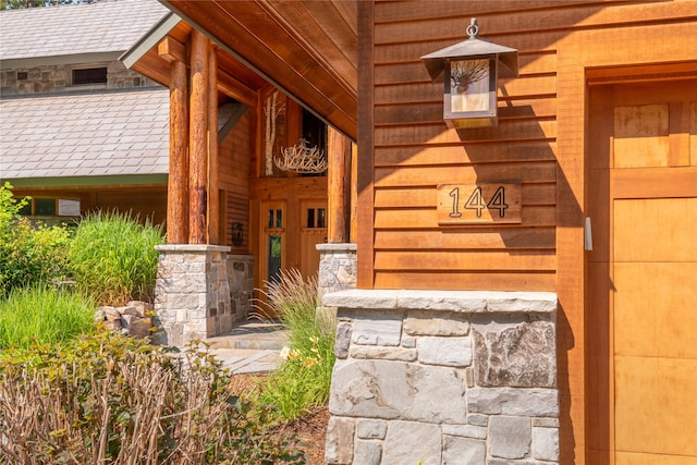 144 S Shore Pl, Seeley Lake, MT 59868 - view of exterior entry with stone siding and covered porch