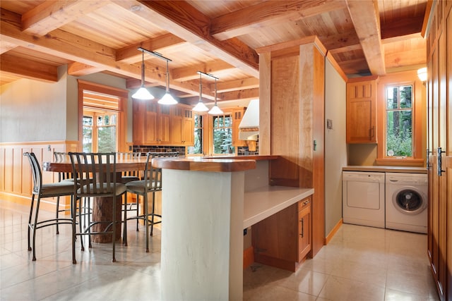 144 S Shore Pl, Seeley Lake, MT 59868 - kitchen with separate washer and dryer, a wooden ceiling with exposed beams, a peninsula, a kitchen bar, and premium range hood