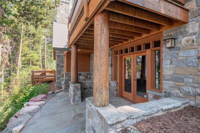 144 S Shore Pl, Seeley Lake, MT 59868 - doorway to property with french doors, stone siding, a patio area, and a chimney