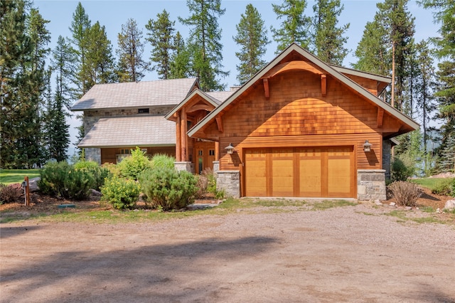 144 S Shore Pl, Seeley Lake, MT 59868 - view of front of property with stone siding, driveway, and a garage