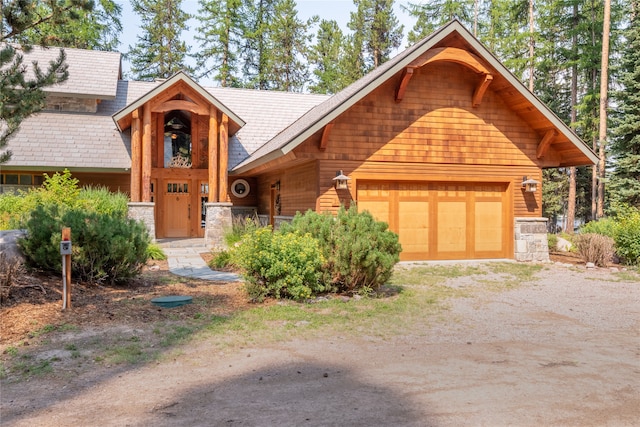 144 S Shore Pl, Seeley Lake, MT 59868 - cabin with stone siding, driveway, and a garage