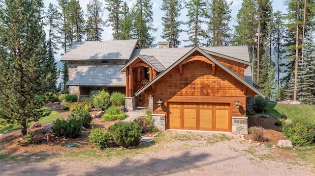 144 S Shore Pl, Seeley Lake, MT 59868 - view of front of property with stone siding, driveway, a chimney, and a garage