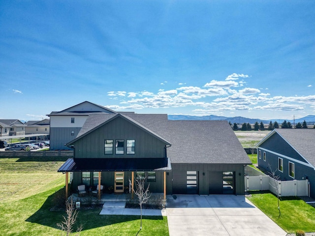 128 Owl Loop, Kalispell, MT 59901 - view of front of property featuring a shingled roof, concrete driveway, a gate, and a mountain view