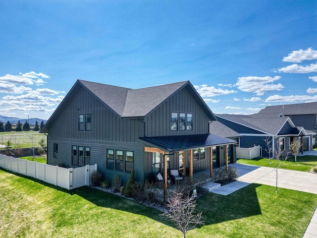 128 Owl Loop, Kalispell, MT 59901 - back of house featuring concrete driveway, board and batten siding, roof with shingles, a standing seam roof, and metal roof