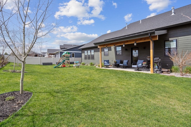 128 Owl Loop, Kalispell, MT 59901 - back of property featuring a playground, a patio, and a shingled roof