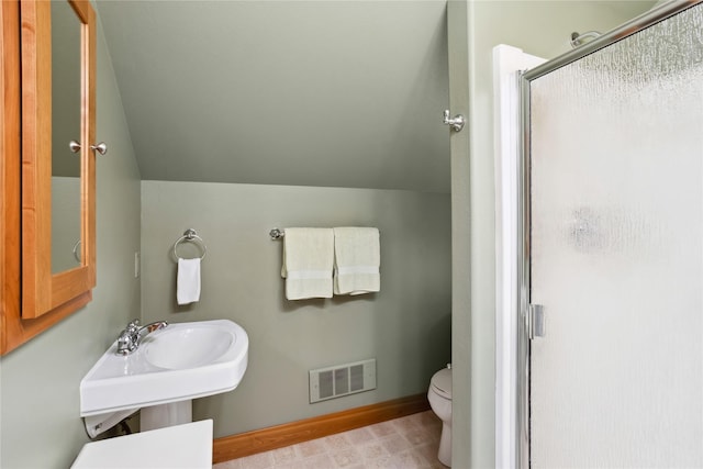 42746 Knuppel Ln, Big Arm, MT 59910 - bathroom with vaulted ceiling, toilet, a shower stall, baseboards, and a sink