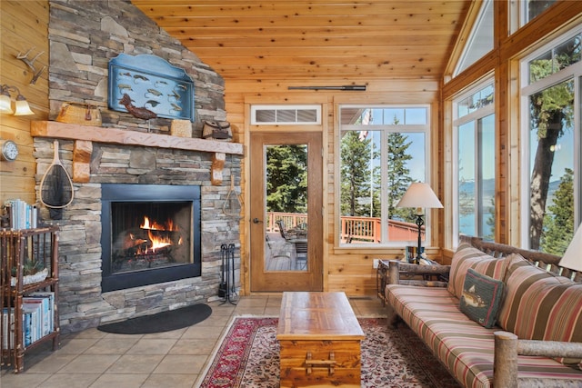 42746 Knuppel Ln, Big Arm, MT 59910 - tiled living room with lofted ceiling, a stone fireplace, healthy amount of natural light, wood walls, and wood ceiling