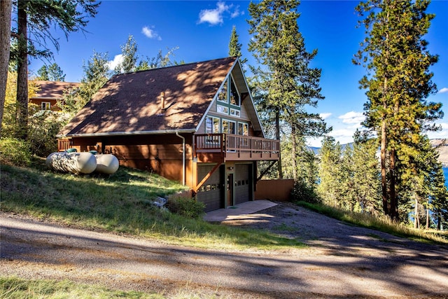 42746 Knuppel Ln, Big Arm, MT 59910 - view of property exterior with dirt driveway, a wooden deck, and a garage