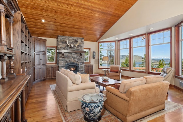 42746 Knuppel Ln, Big Arm, MT 59910 - living area featuring a stone fireplace, light wood finished floors, plenty of natural light, wood ceiling, and high vaulted ceiling