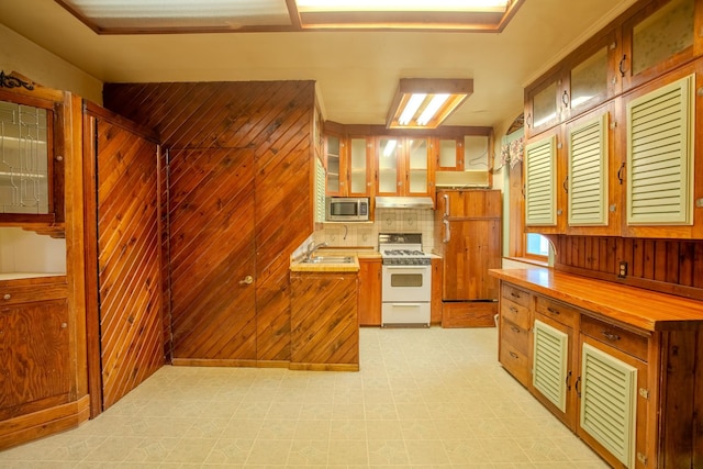 422 11th Ave, Helena, MT 59601 - kitchen featuring a sink, white range with gas cooktop, light floors, stainless steel microwave, and under cabinet range hood