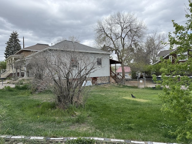 422 11th Ave, Helena, MT 59601 - view of side of home featuring a yard, roof with shingles, and fence