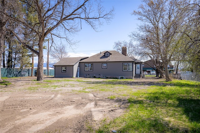 view of side of home featuring fence and a chimney