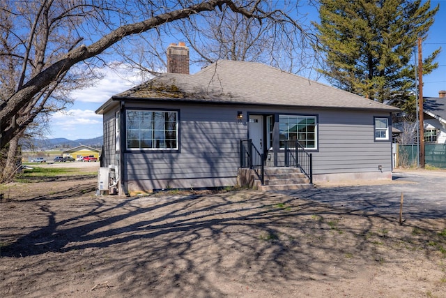 bungalow-style house featuring fence and a chimney