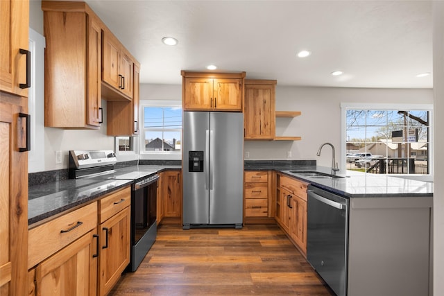 kitchen with plenty of natural light, a sink, a peninsula, open shelves, and appliances with stainless steel finishes