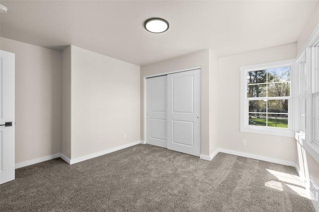 unfurnished bedroom with carpet, baseboards, and a closet
