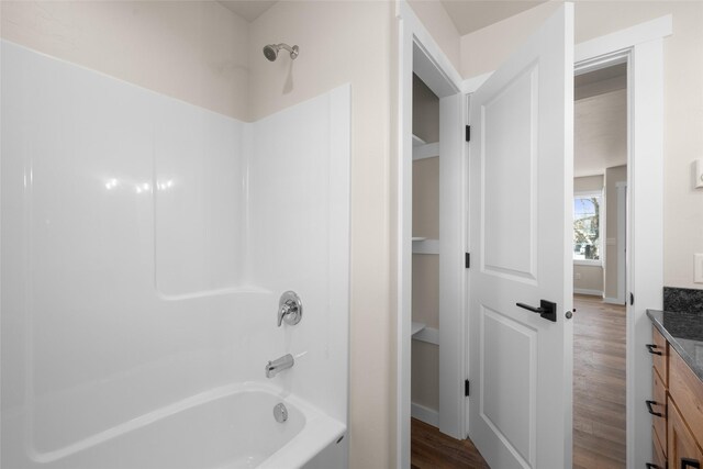 full bathroom featuring vanity, shower / bathtub combination, baseboards, and wood finished floors