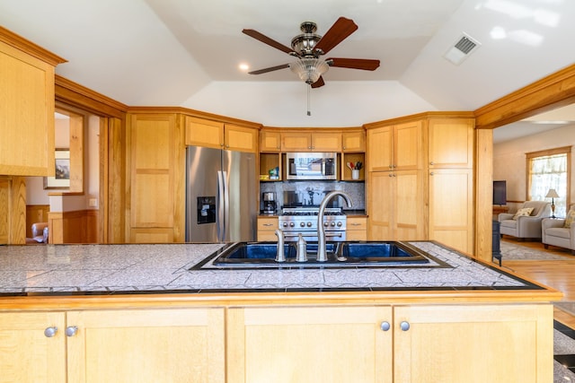 kitchen with a ceiling fan, a sink, stainless steel appliances, visible vents, and lofted ceiling