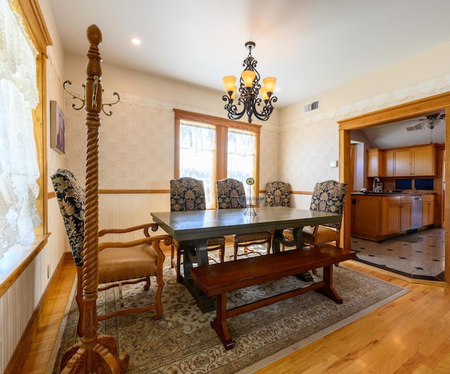 dining area with light wood-type flooring, visible vents, recessed lighting, an inviting chandelier, and wainscoting