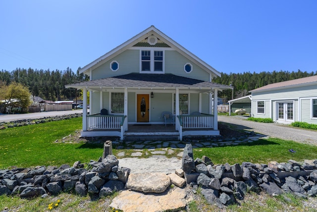 view of front of house with a front yard, french doors, and covered porch