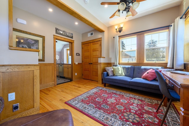 living area with light wood-type flooring, visible vents, recessed lighting, a ceiling fan, and wainscoting