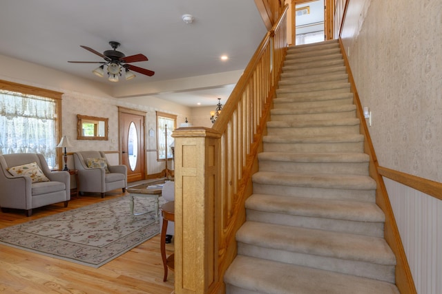 stairway featuring a ceiling fan and wood finished floors