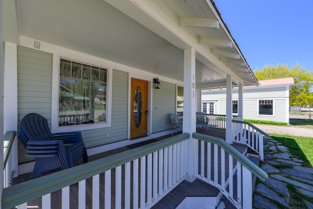 doorway to property featuring covered porch and metal roof