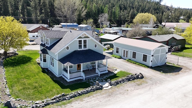 drone / aerial view featuring a residential view and a view of trees