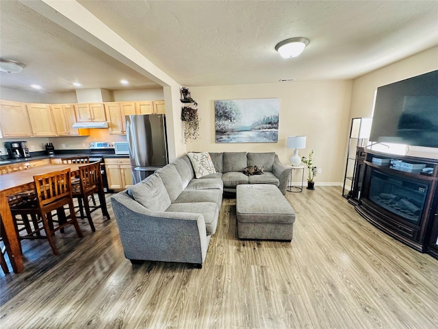 living area with light wood finished floors, recessed lighting, and baseboards