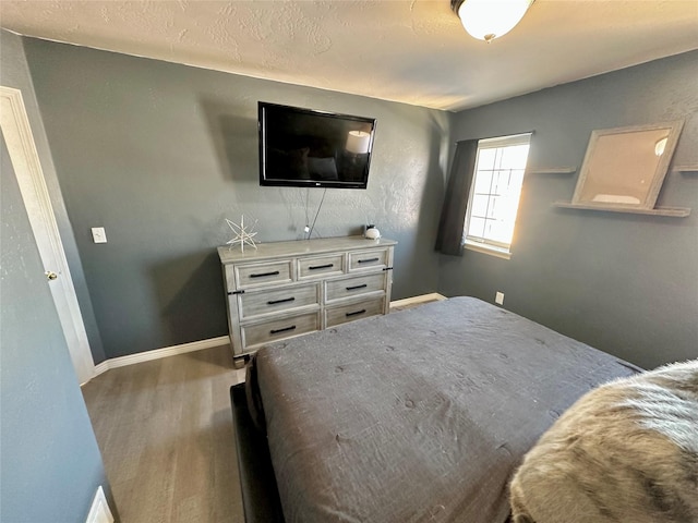 bedroom with wood finished floors and baseboards