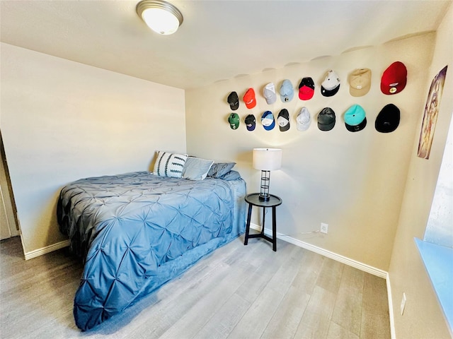 bedroom featuring wood finished floors and baseboards