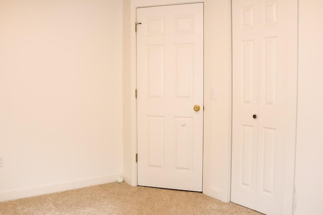interior space featuring baseboards and light carpet