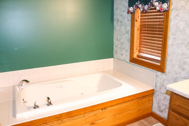 full bath with vanity, a bath, and wallpapered walls