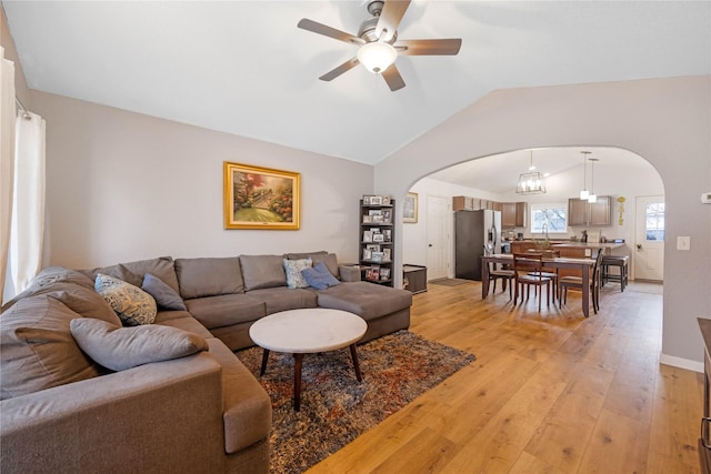 3817 Concord Dr, Missoula, MT 59808 - living room featuring light wood finished floors, vaulted ceiling, a ceiling fan, and arched walkways