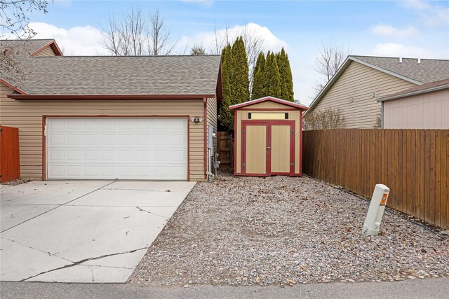 3817 Concord Dr, Missoula, MT 59808 - garage featuring driveway, a shed, and fence