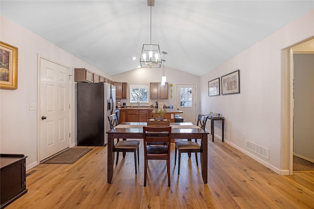 3817 Concord Dr, Missoula, MT 59808 - dining space with light wood-style floors, an inviting chandelier, visible vents, and vaulted ceiling