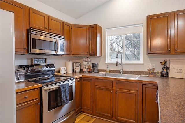 3817 Concord Dr, Missoula, MT 59808 - kitchen with dark countertops, stainless steel appliances, brown cabinets, and a sink