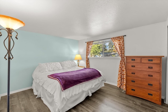 bedroom with baseboards and wood finished floors
