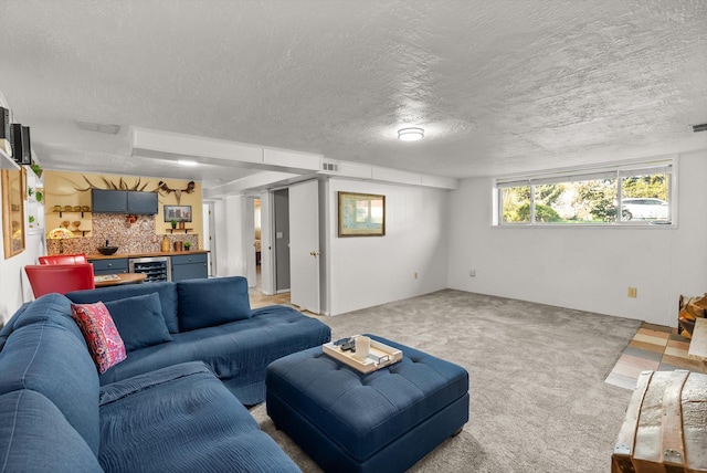 living area featuring light colored carpet, a textured ceiling, and beverage cooler