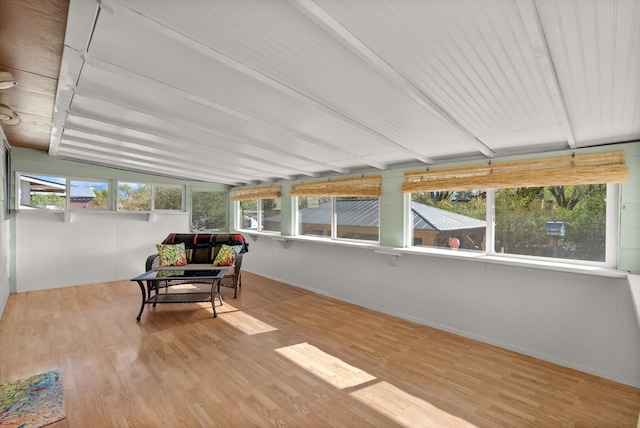 sunroom with baseboards and wood finished floors