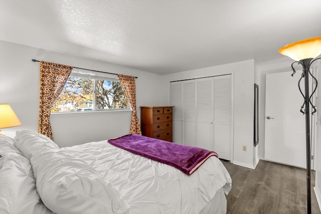 bedroom featuring a closet, baseboards, and dark wood-style floors
