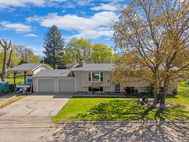 tri-level home with stone siding, concrete driveway, a garage, a front lawn, and a chimney