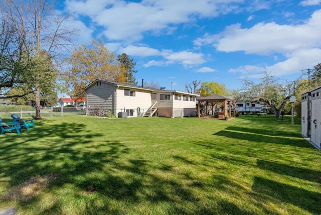 back of house featuring stairway, a gazebo, and a lawn