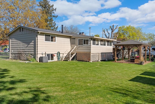 rear view of house featuring a gazebo, fence, stairs, central AC, and a lawn