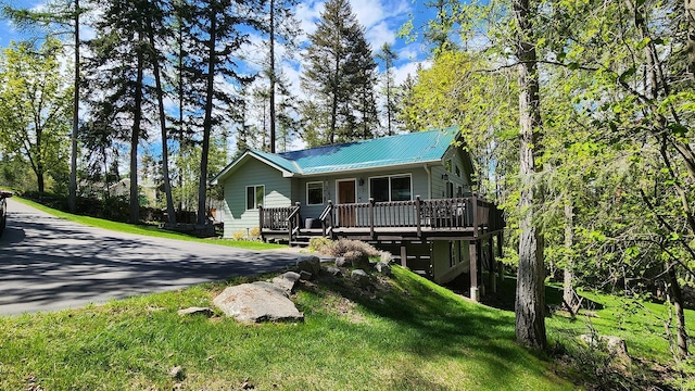 view of front of house featuring metal roof, a porch, and a front yard