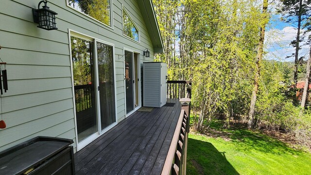 wooden terrace featuring a lawn