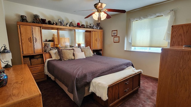 bedroom featuring dark colored carpet and a ceiling fan
